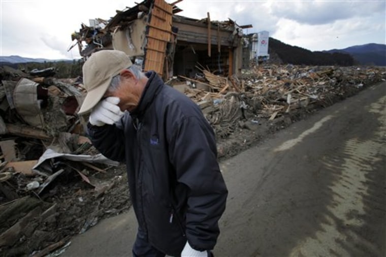 Katsuo Maiya, 73, weeps in front of the rubble where his sister-in-law's house stood in Rikuzentakata, Iwate Prefecture, northern Japan, on Thursday. Maiya's sister-in-law and her husband were killed in Friday's disaster. 